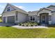 Charming home featuring a gray exterior, manicured landscaping, with a brick paved driveway and walkway to the front door at 17781 Sw 72Nd Street Rd, Dunnellon, FL 34432