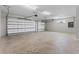 Spacious garage with two garage doors, concrete flooring and bright lighting fixtures at 17781 Sw 72Nd Street Rd, Dunnellon, FL 34432