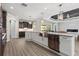 Modern kitchen featuring a stainless steel farmhouse sink and view to the living area and fireplace at 17781 Sw 72Nd Street Rd, Dunnellon, FL 34432