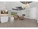 Inviting living room showcasing neutral walls, recessed lights, wood flooring, fireplace, and kitchen access at 17781 Sw 72Nd Street Rd, Dunnellon, FL 34432