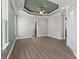 Large main bedroom featuring wood floors, tray ceilings, and ensuite bath at 17781 Sw 72Nd Street Rd, Dunnellon, FL 34432