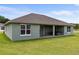 Home's backyard featuring a covered patio and neatly manicured lawn at 17887 Sw 72Nd Street Rd, Dunnellon, FL 34432