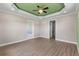 Bedroom features a tray ceiling, ceiling fan, and two entryways at 17887 Sw 72Nd Street Rd, Dunnellon, FL 34432