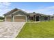 Inviting curb appeal with a three-car garage and well-manicured lawn at 17887 Sw 72Nd Street Rd, Dunnellon, FL 34432