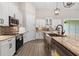 Modern kitchen has stainless steel appliances, stone countertops and a large farmhouse sink at 17887 Sw 72Nd Street Rd, Dunnellon, FL 34432