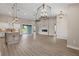 Open-concept living room features modern light fixtures, wood floors, and a sliding glass door at 17887 Sw 72Nd Street Rd, Dunnellon, FL 34432