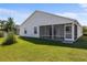 A view of the home's backyard and screened in patio with green grass and partial shade at 2297 Montbrook Pl, The Villages, FL 32162