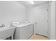 Convenient laundry room with utility sink, tile flooring, and washer-dryer at 2297 Montbrook Pl, The Villages, FL 32162