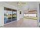 A screened in porch with ceiling fans and tile flooring, accessible through sliding glass doors at 2297 Montbrook Pl, The Villages, FL 32162