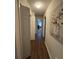 Hallway showcasing modern artwork, hardwood floors, and access to multiple rooms at 3875 Shaftbury Pl, Oviedo, FL 32765