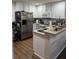 Well-lit kitchen boasts white cabinets, stainless steel appliances, and modern countertops at 3875 Shaftbury Pl, Oviedo, FL 32765