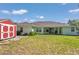 Expansive backyard showcasing the property's shed, lush greenery, and the home's rear facade at 3968 Sw 131St Place Rd, Ocala, FL 34473