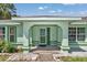 Welcoming front entryway with decorative columns and a charming green front door at 3968 Sw 131St Place Rd, Ocala, FL 34473