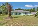 Well-manicured lawn complements the home's light green exterior, creating a welcoming facade at 3968 Sw 131St Place Rd, Ocala, FL 34473