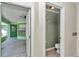 Image shows a hallway view of a half bath and access to an enclosed porch with a ceiling fan at 3968 Sw 131St Place Rd, Ocala, FL 34473