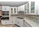 Modern kitchen featuring white cabinets, granite countertops, stainless steel appliances, and tiled backsplash at 3968 Sw 131St Place Rd, Ocala, FL 34473