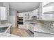 Bright kitchen with white cabinets, granite counters, and stylish backsplash at 3968 Sw 131St Place Rd, Ocala, FL 34473