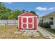 Red and white storage shed is set on a stone paver path in the back yard at 3968 Sw 131St Place Rd, Ocala, FL 34473