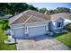 Aerial view of a well-maintained home featuring a spacious driveway leading to a two-car garage at 4261 Sw 62Nd Loop, Ocala, FL 34474