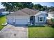 Charming single-story home featuring a three-car garage, well-maintained lawn, and stone accents at 4261 Sw 62Nd Loop, Ocala, FL 34474