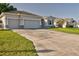 The front exterior features a large driveway, attached garage, and well-maintained lawn at 4261 Sw 62Nd Loop, Ocala, FL 34474