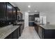 Modern kitchen with dark cabinetry, stainless steel appliances, and granite countertops at 4261 Sw 62Nd Loop, Ocala, FL 34474
