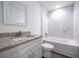 Bathroom featuring a vanity with granite countertop, a toilet, and tub shower with tiled walls at 8881 Sw 138Th Ln, Ocala, FL 34473