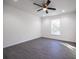 Sunlit bedroom featuring gray flooring, white walls, ceiling fan and a window with a view at 8881 Sw 138Th Ln, Ocala, FL 34473