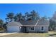 Charming single-story home with a gray roof, attached garage, and freshly landscaped front yard at 8881 Sw 138Th Ln, Ocala, FL 34473
