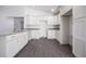 Contemporary kitchen featuring white cabinets, granite countertops, and stainless steel sink with gray vinyl floor at 8881 Sw 138Th Ln, Ocala, FL 34473