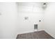 Compact laundry room with white walls, modern hookups, overhead shelving and gray vinyl flooring at 8881 Sw 138Th Ln, Ocala, FL 34473