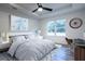 Serene bedroom with tray ceilings, a ceiling fan, and a large window offering backyard views at 8900 Sw 138Th Ln, Ocala, FL 34473