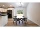 Bright dining area featuring a modern light fixture, a large window, and a contemporary round table at 8900 Sw 138Th Ln, Ocala, FL 34473