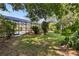 Lush backyard featuring an enclosed pool area, mature trees, and manicured lawn at 2135 Se 12Th St, Ocala, FL 34471