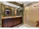 Bathroom featuring double sinks, a walk-in shower, and decorative wallpaper at 2135 Se 12Th St, Ocala, FL 34471