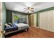 Green bedroom featuring a window overlooking the pool area, hardwood floors, and built-in shelves at 2135 Se 12Th St, Ocala, FL 34471
