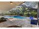 Enclosed pool area featuring a tiled swimming pool with outdoor seating and a lush landscaped perimeter at 2135 Se 12Th St, Ocala, FL 34471