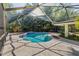 Enclosed pool area with unique pool design, concrete patio, and tropical landscaping at 2135 Se 12Th St, Ocala, FL 34471
