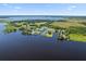 An aerial view showcases a beautiful lake community with homes nestled along the serene waterfront landscape at 3943 Nw 219Th Street Rd, Micanopy, FL 32667