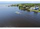 Aerial view of seaplane moving on lake, with luxury homes, docks, and verdant landscape at 3943 Nw 219Th Street Rd, Micanopy, FL 32667