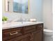 Bathroom vanity with dark wood cabinets, marble countertop, gold framed mirror and polished chrome faucet at 3943 Nw 219Th Street Rd, Micanopy, FL 32667