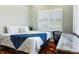 Bedroom featuring large bed, white shutters, view of outdoors and workstation desk at 3943 Nw 219Th Street Rd, Micanopy, FL 32667
