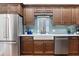 Modern kitchen features stainless steel appliances, farmhouse sink, beautiful backsplash and custom wood cabinets at 3943 Nw 219Th Street Rd, Micanopy, FL 32667