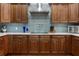 Kitchen featuring rich wood cabinetry, stainless steel appliances, and a stylish backsplash creating a warm and inviting space at 3943 Nw 219Th Street Rd, Micanopy, FL 32667
