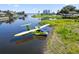 A yellow seaplane rests on the shore next to the clear water, near lush green landscaping and idyllic homes at 3943 Nw 219Th Street Rd, Micanopy, FL 32667