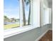 Bright room with view of the water and palm trees from the window with white shutters and wood floors at 3943 Nw 219Th Street Rd, Micanopy, FL 32667