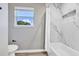 Bathroom featuring a tub with shower, window, and tile surround at 716 Golfview St, Orlando, FL 32804
