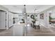 Modern dining area features white cabinets, dining table with stylish lighting, and an adjacent study at 716 Golfview St, Orlando, FL 32804