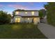 Charming two-story home with a well-maintained lawn and beautifully landscaped front yard at twilight at 716 Golfview St, Orlando, FL 32804