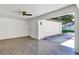 Spacious garage with white walls, ceiling fan, and gray tile flooring with access door at 716 Golfview St, Orlando, FL 32804